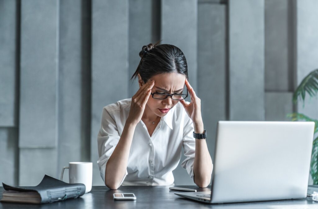 A person massaging their temples to relieve headache symptoms.