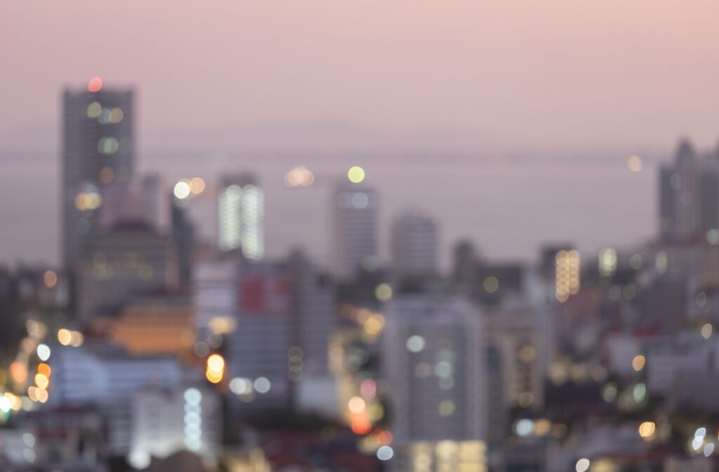 A blurry view of a city's highrises in evening light.
